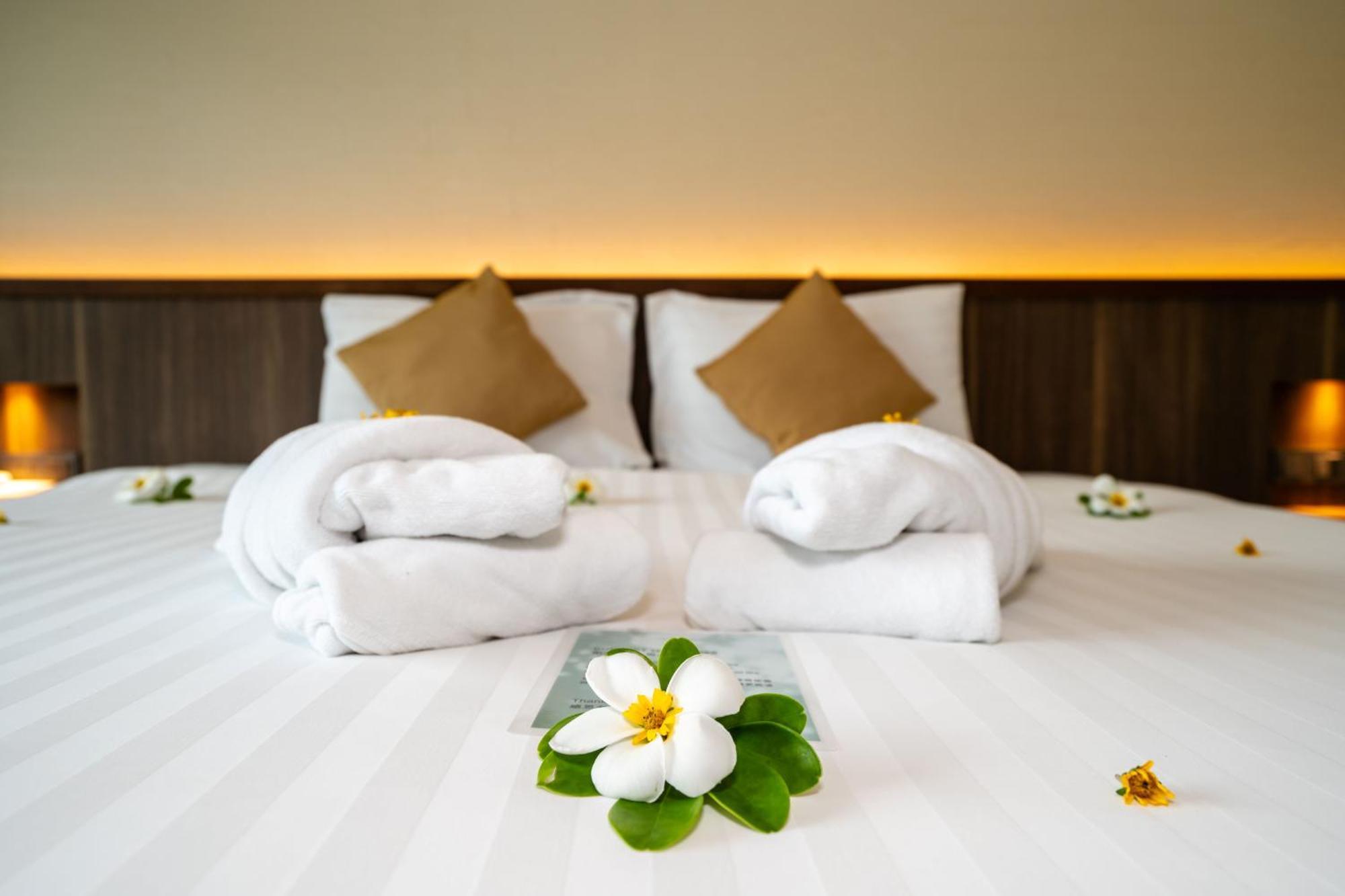 منتجع آند فيلاز لو Rawai المظهر الخارجي الصورة A bed with towels and flowers